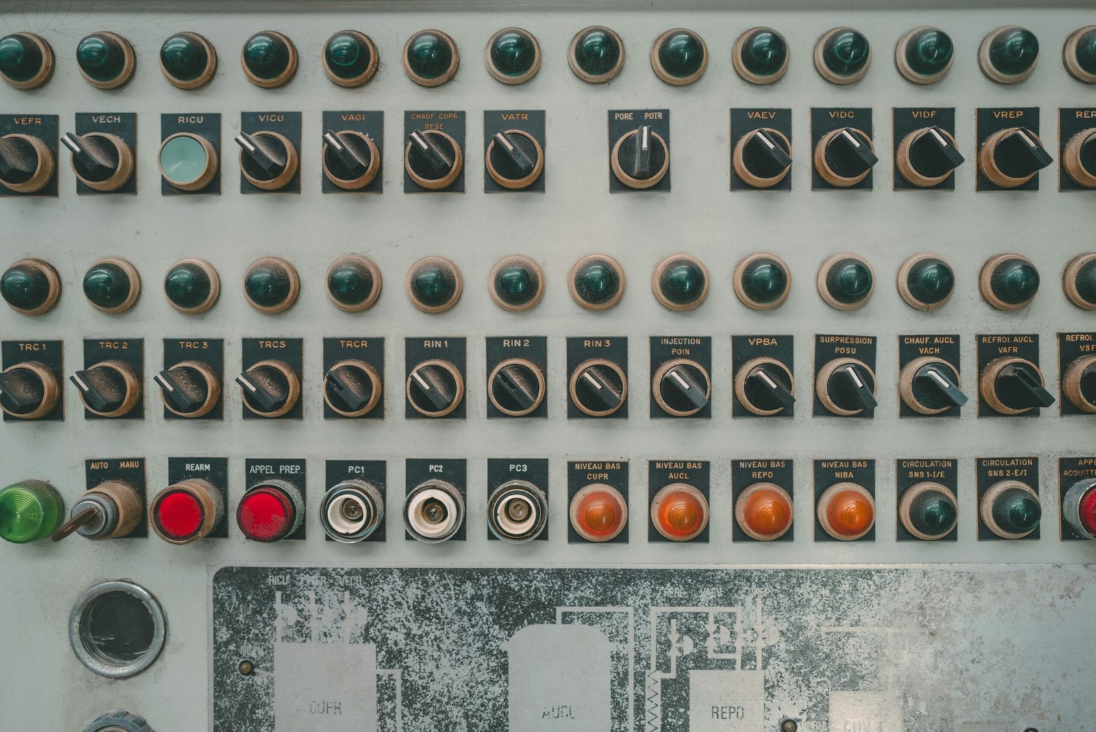 Close-up of a vintage industrial control panel with multiple buttons and switches.